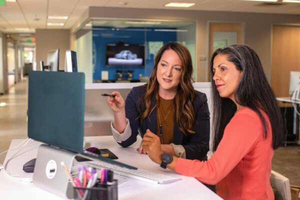 Chez Logos Praxis, nous structurons les soft skills comme un levier de performance durable. Deux managers échangent autour d’un poste de travail, illustrant la transmission, la coopération et la prise de décision au cœur de l’action.