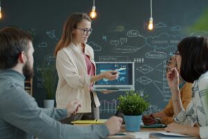 Une équipe en formation collaborative analyse ses indicateurs de performance. Cette image incarne l’importance du suivi post-formation et de l’ancrage des apprentissages dans la durée, au cœur de l’approche Logos Praxis, où chaque formation devient un levier de transformation durable.